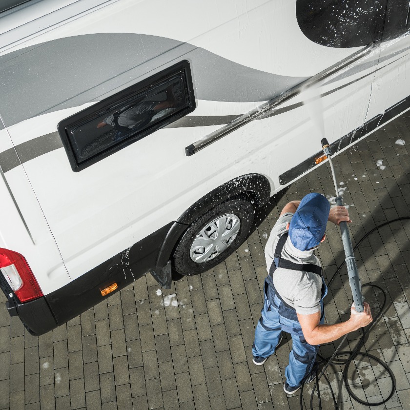 Rv service worker pressure washing camper van jpg